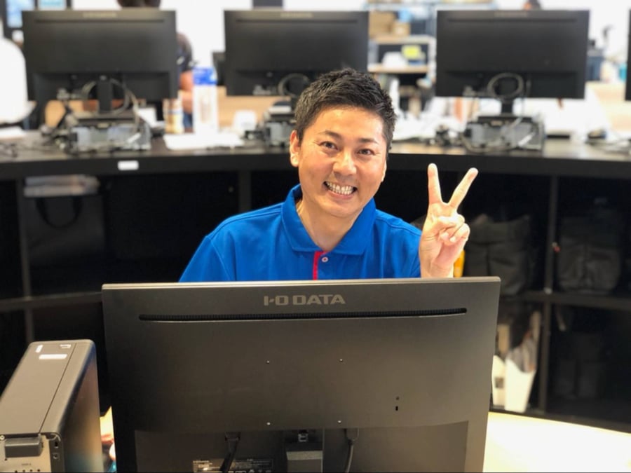 オフィスでピースサインをしている、マルト水谷のエリア長